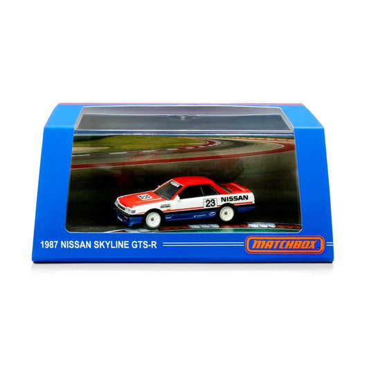 Matchbox 1987 Nissan Skyline GTS-R diecast model car in its original blue window display packaging, featuring a red, white, and blue car with racing decals.