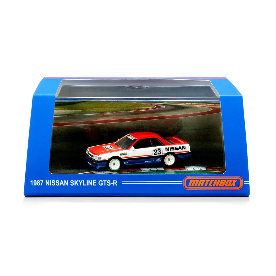 Matchbox 1987 Nissan Skyline GTS-R diecast model car in its original blue window display packaging, featuring a red, white, and blue car with racing decals.