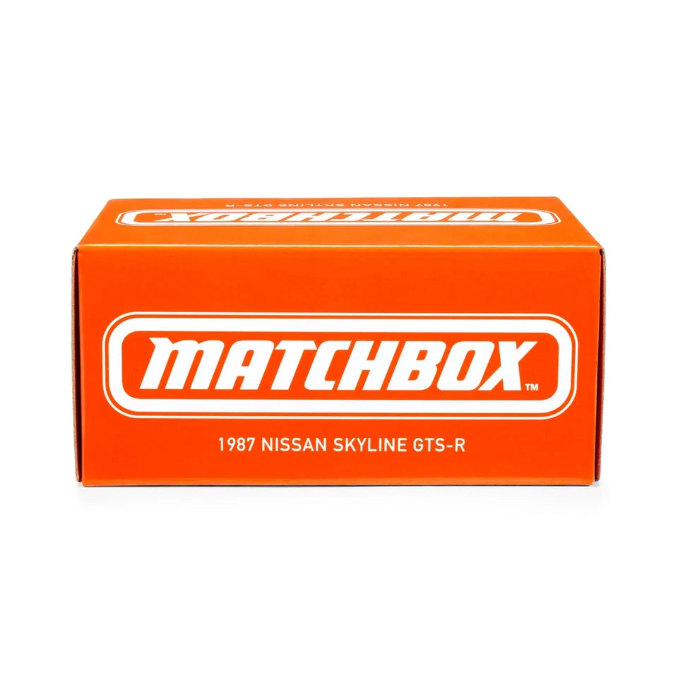 An orange Matchbox retail box featuring the white Matchbox logo and text reading '1987 Nissan Skyline GTS-R' on a clean white background.